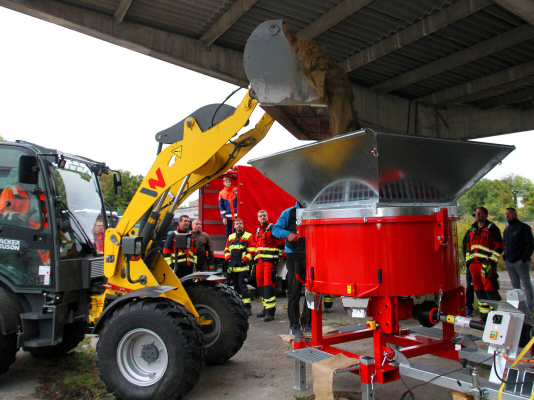 Radlader füllt Sand in Sandsackfüllanlage