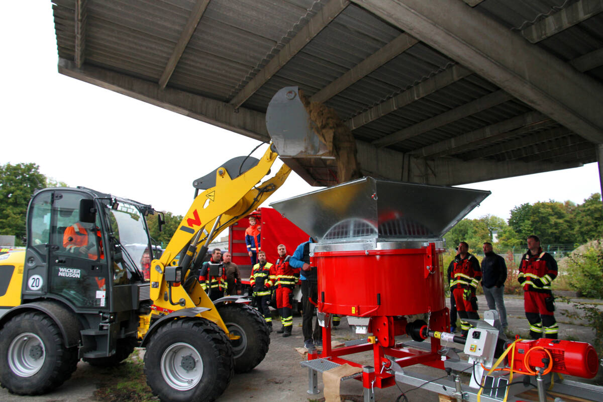 Radlader füllt Sand in Sandsackfüllanlage
